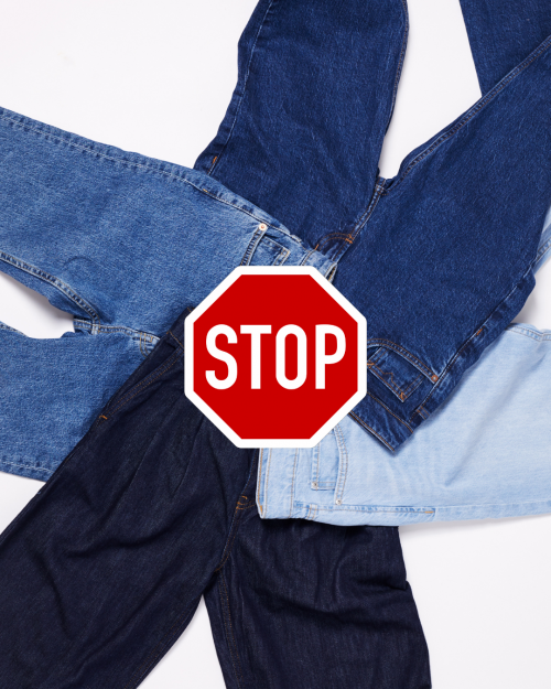 4 jeans posés à plat avec un panneau stop au milieu